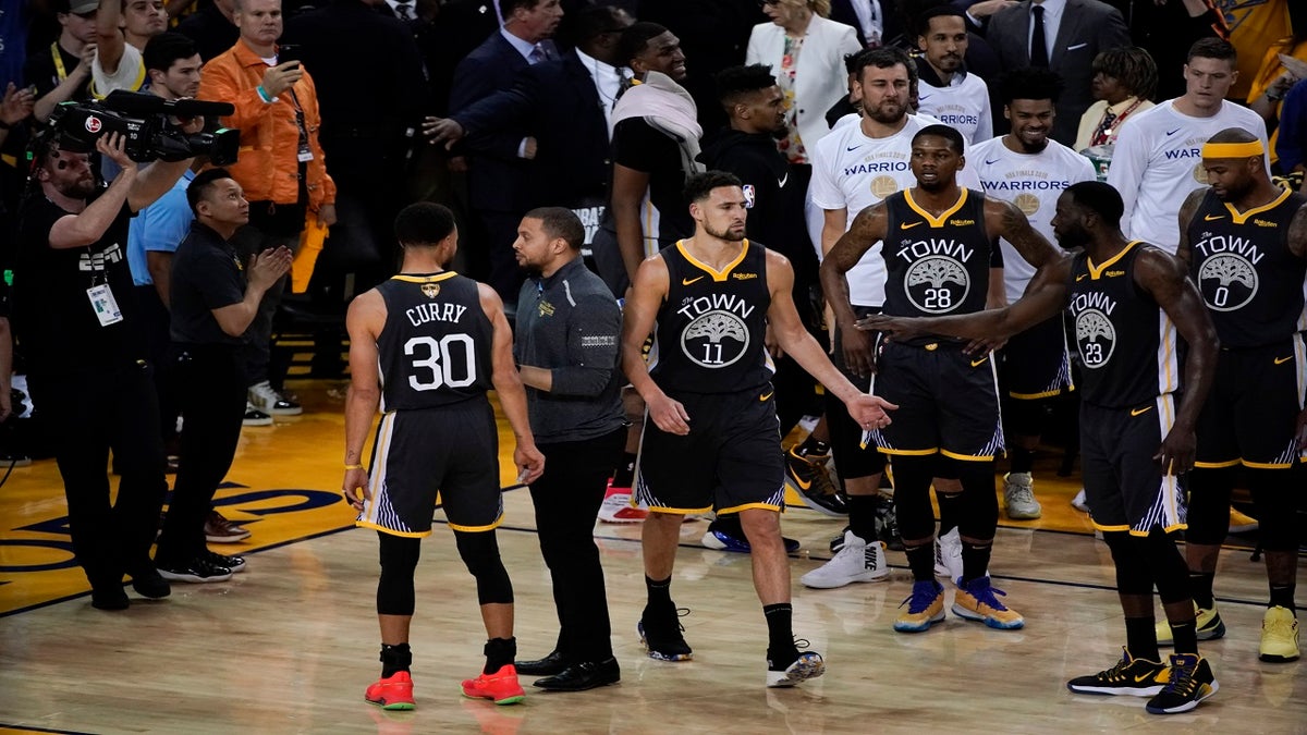 Golden State Warriors guard Klay Thompson (11) is greeted by teammates after walking back onto the court to shoot free throws after an injury against the Toronto Raptors during the second half of Game 6. 