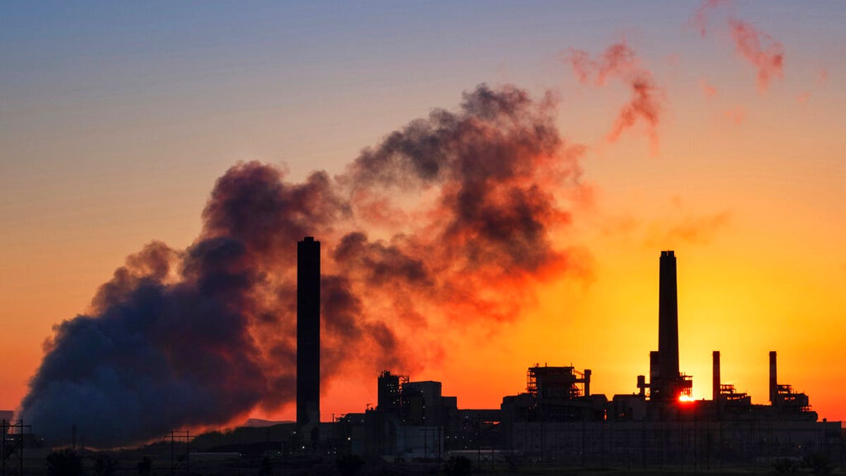 FILE - In this July 27, 2018, file photo, the Dave Johnson coal-fired power plant is silhouetted against the morning sun in Glenrock, Wyo. (AP Photo/J. David Ake)