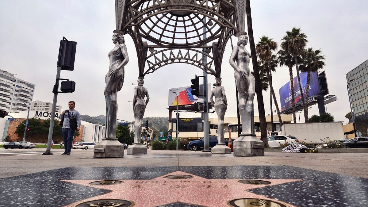 A pedestrian walks past the "Four Ladies of Hollywood" gazebo on Hollywood Boulevard in Los Angeles, on Wednesday June 19, 2019. Officials say someone climbed the more than two-story tall public art piece and stole a statue of Marilyn Monroe. Los Angeles Councilman Mitch O'Farrell says a witness saw someone climb the gazebo on the Hollywood Walk Fame and saw off the statue. (AP Photo/Richard Vogel)