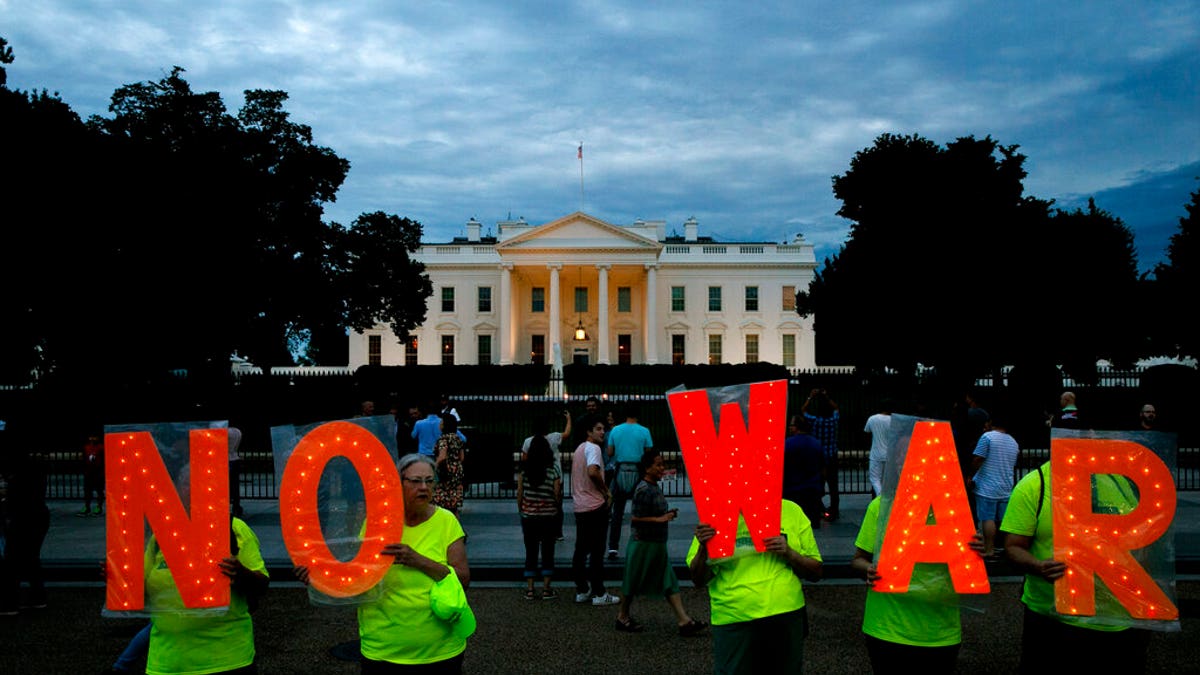 Protesters hold signs spelling out, "No War," outside the White House, Thursday June 20, 2019, in Washington, after President Donald Trump tweeted that "Iran made a very big mistake" by shooting down a U.S. surveillance drone over the Strait of Hormuz in Iran.