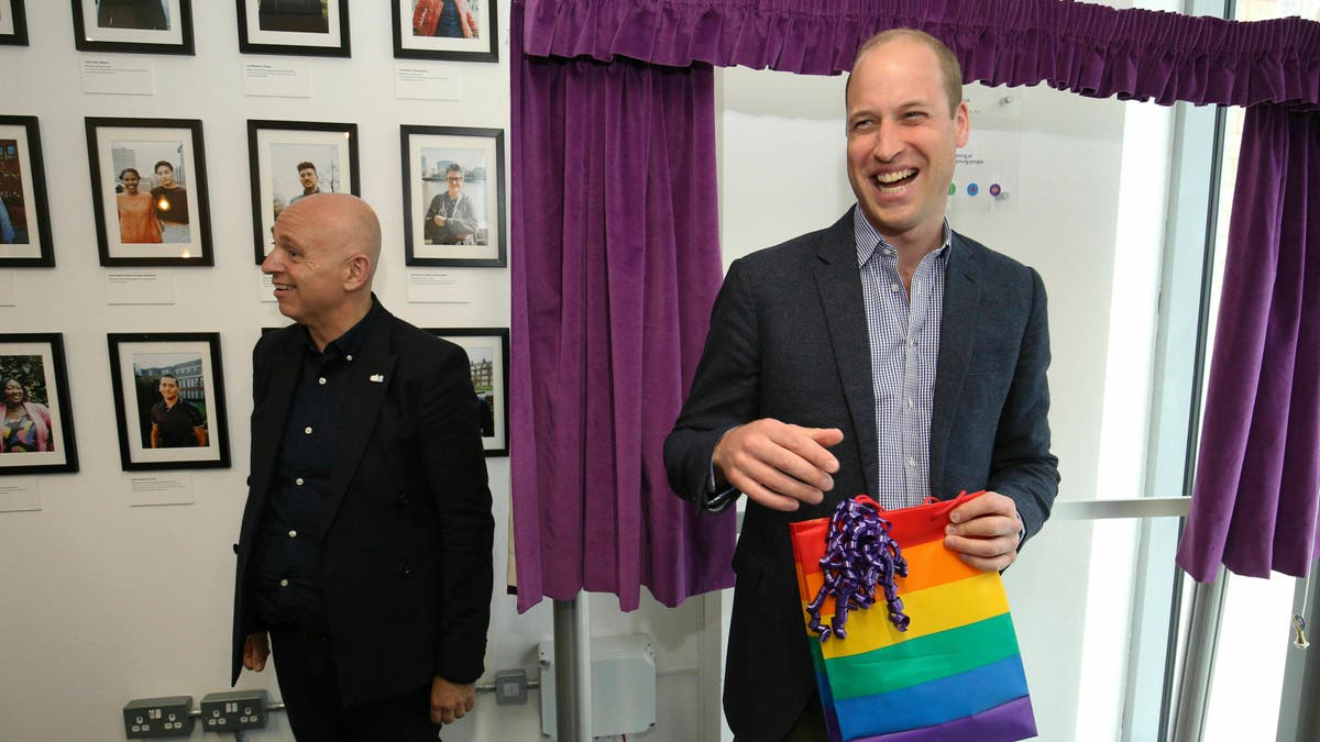 Prince William, the Duke of Cambridge, reacts to receiving a gift bag from trust chief executive officer, Tim Sigsworth, during a visit to the Albert Kennedy in London on June 26, 2019.