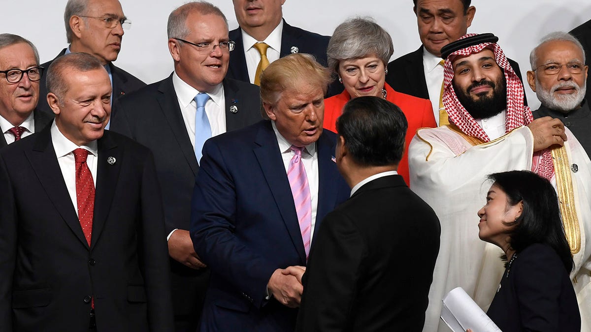 President Donald Trump, center, shakes hands with Chinese President Xi Jinping as they gather for a group photo at the G-20 summit in Osaka, Japan, Friday, June 28, 2019. (AP Photo/Susan Walsh)
