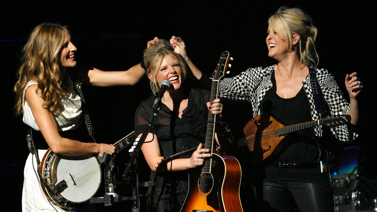 Oct. 18, 2007: Emily Robison, left, and Martie Maguire, right, adjust Natalie Maines' hair as The Chicks, formerly the Dixie Chicks, perform at the new Nokia Theatre in Los Angeles. 