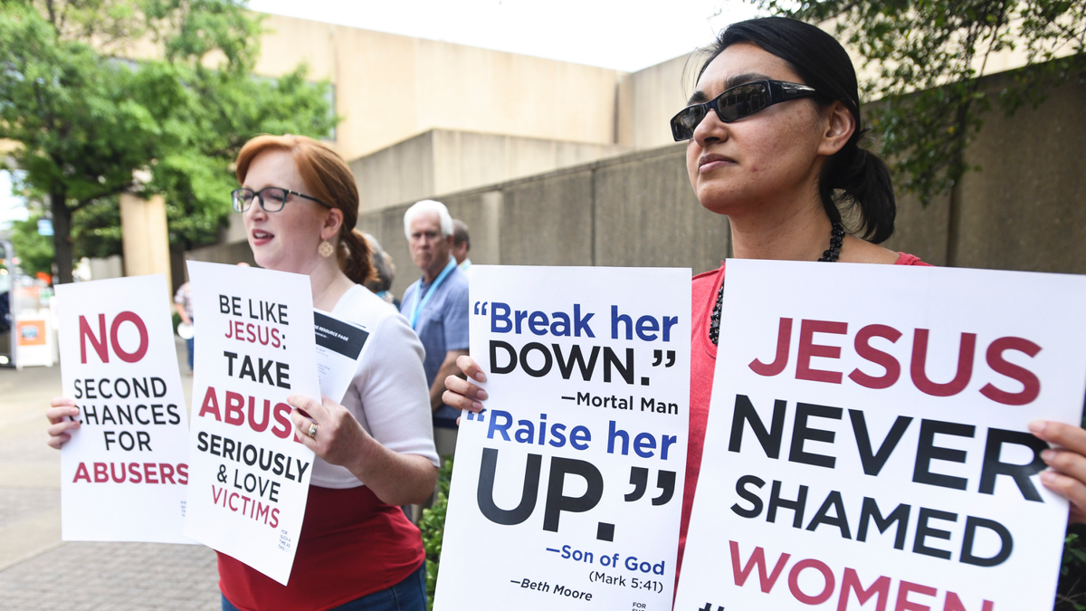 Jennifer Weed, left, and Nisha Virani, both of Birmingham, Ala., demonstrate outside Southern Baptist Convention's annual meeting Tuesday, June 11, 2019, during a rally in Birmingham, Ala. The For Such A Time As This protest calls for a change in the way the SBC views and treats women and demands action to combat sexual abuse within the establishment. (AP Photo/Julie Bennett)