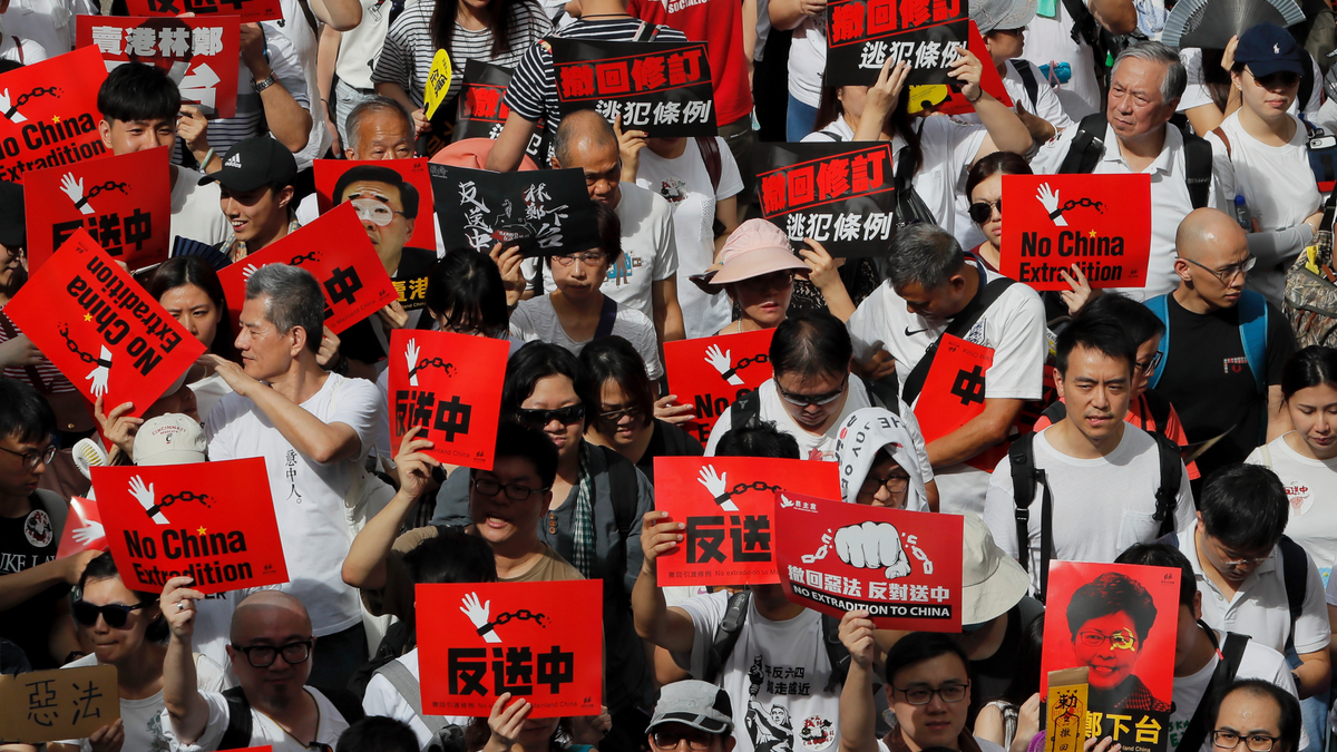 Protesters hold placards march in a rally against the proposed amendments to extradition law in Hong Kong, Sunday, June 9, 2019. (AP Photo/Kin Cheung)