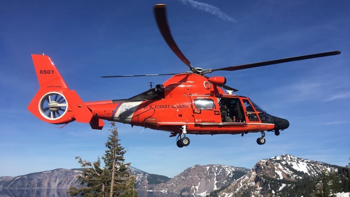 An MH-65 Dolphin helicopter landing at a Crater Lake parking area to transfer the injured man to AirLink Critical Care Transport on Monday. (U.S. Coast Guard photo courtesy of Sector North Bend)