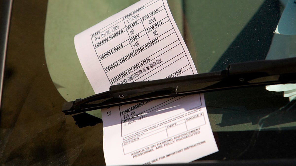 A parking ticket on the windshield of a car.