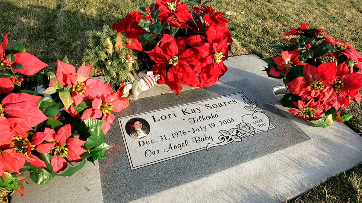 Flowers and a Christmas decoration surround the grave of Lori Hacking in the Orem City Cemetery, minus the Hacking family name Dec. 6, 2004, in Orem, Utah. (Photo by George Frey/Getty Images)
