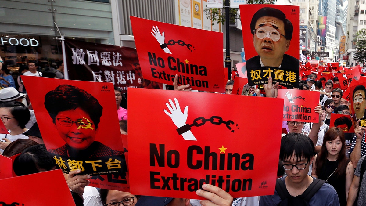 Demonstrators hold signs during a protest to demand authorities scrap a proposed extradition bill with China, in Hong Kong, China June 9, 2019.