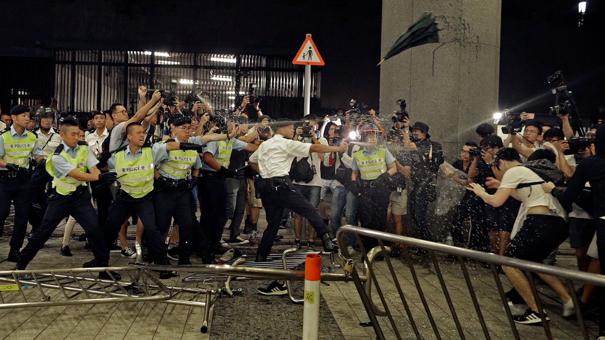 Police officers use pepper spray against protesters in a rally against the proposed amendments to the extradition law at the Legislative Council in Hong Kong during the early hours of Monday, June 10, 2019.