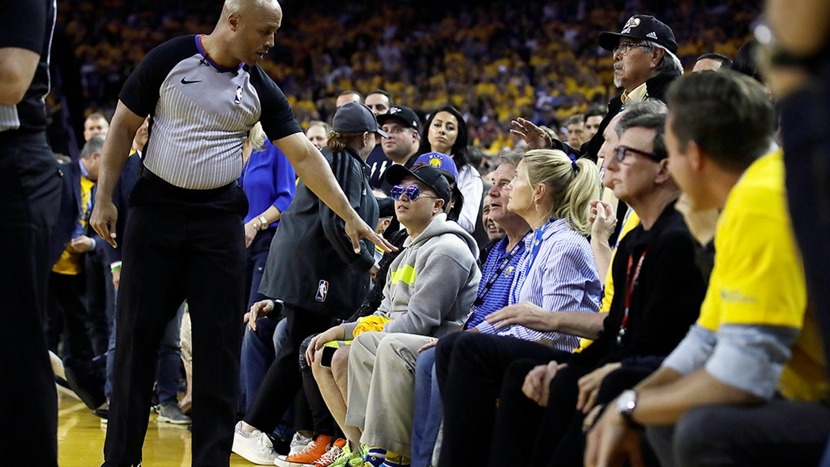 Referee Marc Davis, left, gesturing toward Mark Stevens, partially obscured in blue shirt, after the incident with Kyle Lowry. (AP Photo/Ben Margot)