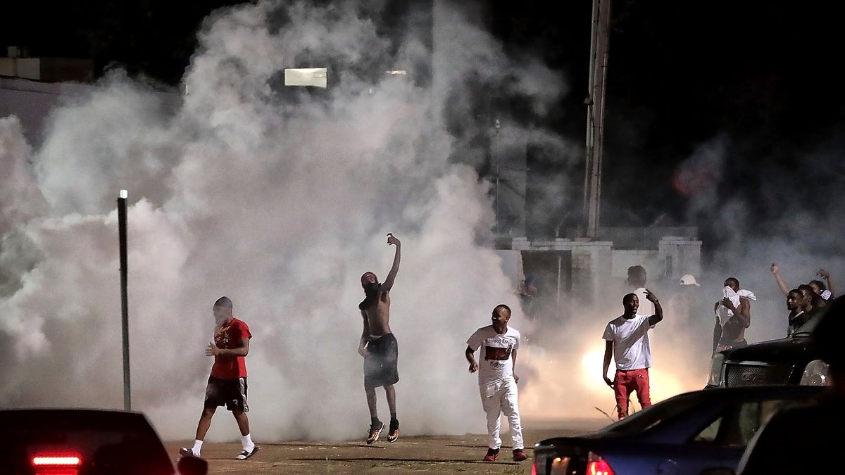 Frayser community residents taunt authorities as protesters take to the streets in anger against the shooting of a youth identified by family members as Brandon Webber by U.S. Marshals earlier in the evening, Wednesday, June 12, 2019, in Memphis, Tenn. (Associated Press)
