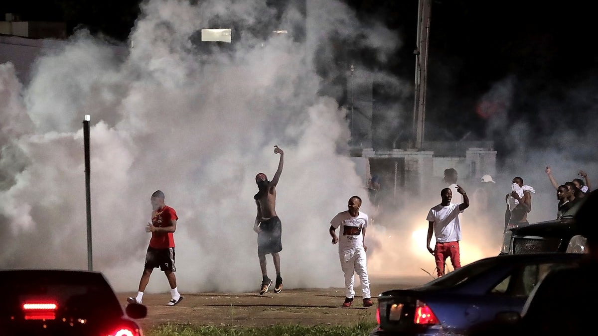 Frayser community residents taunt authorities as protesters take to the streets in anger against the shooting of a youth identified by family members as Brandon Webber by U.S. Marshals earlier in the evening, Wednesday, June 12, 2019, in Memphis, Tenn. (Associated Press)