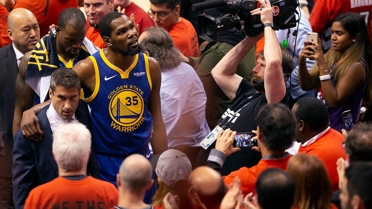 Golden State Warriors forward Kevin Durant glances up at the stands as he walks off the court after sustaining an injury during first half basketball action in Game 5 of the NBA Finals in Toronto, Monday, June 10, 2019. (Chris Young/The Canadian Press via AP)
