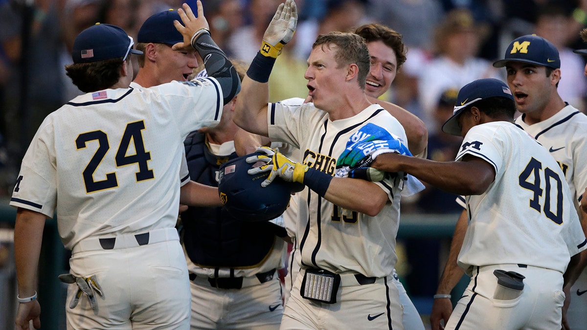 Michigan's Jimmy Kerr, center, is congratulated after hitting a 2-run home run against Vanderbilt during the seventh inning in Game 1 of the NCAA College World Series baseball finals in Omaha, Neb., Monday, June 24, 2019. (AP Photo/Nati Harnik)