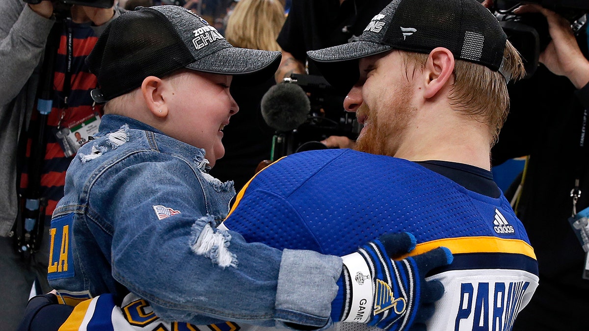 St. Louis Blues Colton Parayko lifts young fan Laila Anderson, left, while the team celebrated on the ice after the Blues defeated the Boston Bruins in Game 7 of the NHL Stanley Cup Final, Wednesday, June 12, 2019, in Boston. (AP Photo/Michael Dwyer)