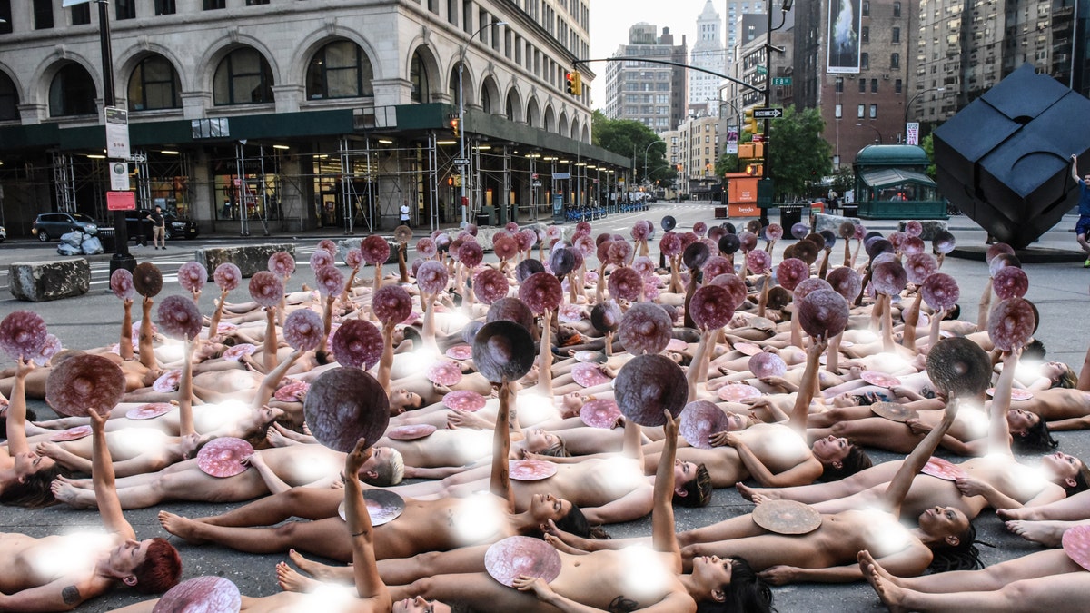 People pose nude for a photo shoot by artist Spencer Tunick in front of Facebook's New York headquarters in Manhattan Sunday. (Photo by Stephanie Keith/Getty Images)
