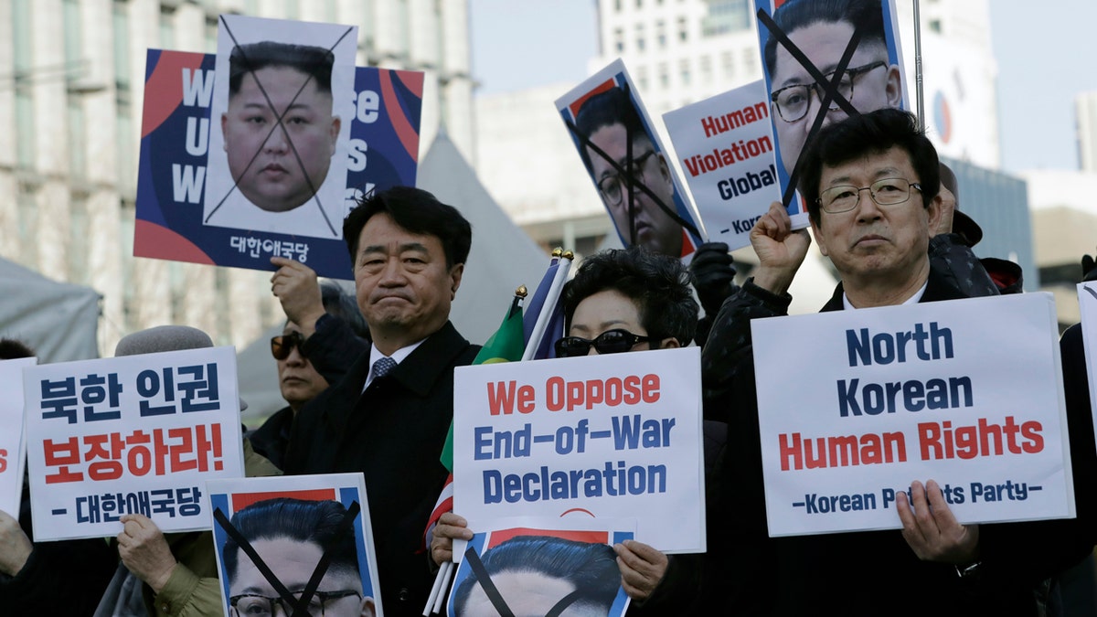In this Feb. 26, 2019, file photo, South Korean protesters and North Korean defectors hold portraits of North Korean leader Kim Jong Un.