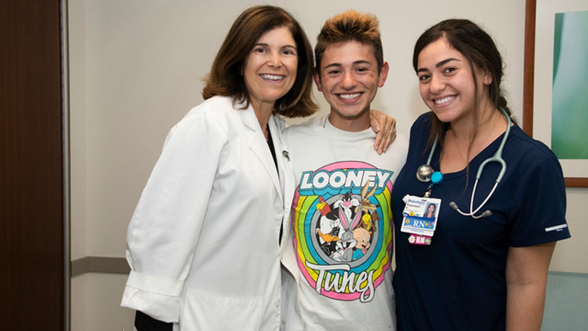 Michael Pruitt is pictured with Dr. Angel Chudler and nurse Yasmeen Bachir, who helped bring him back to life after he had no vital signs for 20 minutes. 