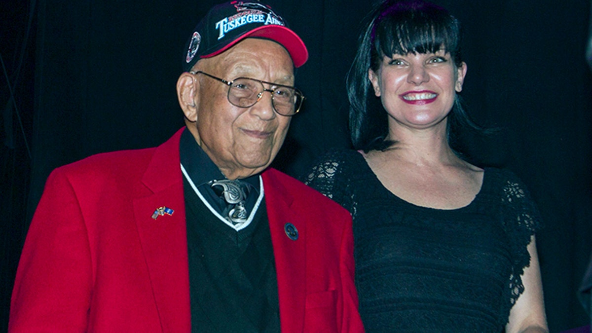 Lt. Col. Bob Friend, a Tuskegee Airman, stands onstage with actress Pauley Perrette during a benefit concert at The House of Blues in Los Angeles in 2013. (Photo by Paul A. Hebert/Invision/AP, File)