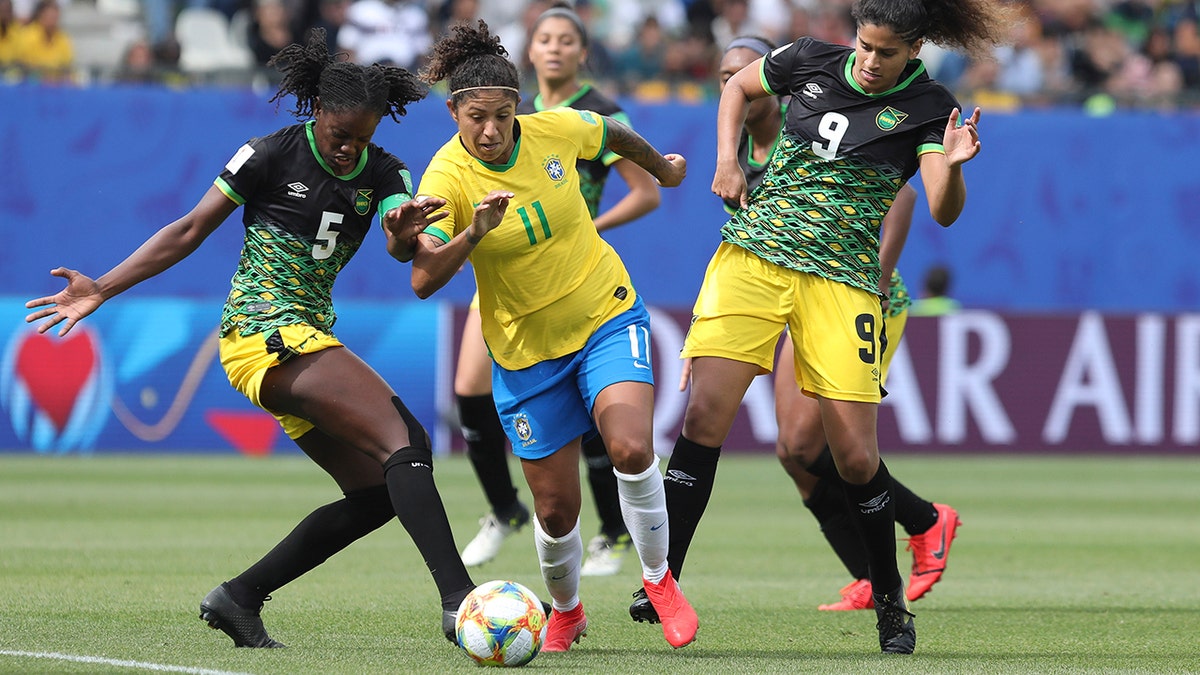 Brazil's Cristiane, center, competes for the ball with Jamaica's Konya Plummer, left, and Jamaica's Marlo Sweatman during the Women's World Cup Group C soccer match between Brazil and Jamaica in Grenoble, France, Sunday, June 9, 2019. (AP Photo/Laurent Cipriani)