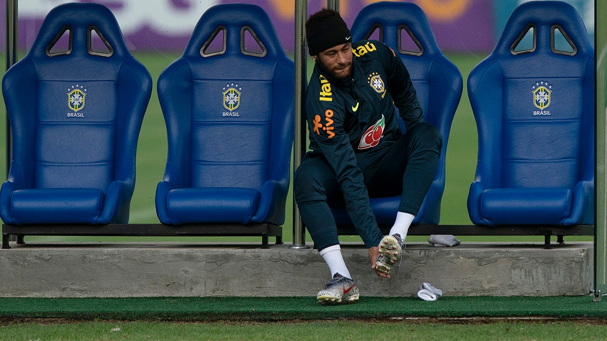 Brazil's Neymar puts on his cleats during a practice session of the national soccer team at the Granja Comary training center ahead the Copa America tournament in Teresopolis, Brazil, Tuesday, June 4, 2019. (AP Photo/Leo Correa)