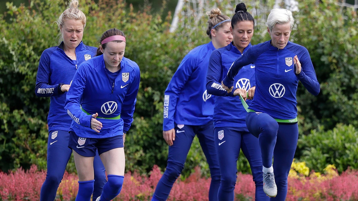 US player Megan Rapinoe, front right, stretches with Ali Krieger and other team members during a US women's soccer team training session at the Tottenham Hotspur training center in London (AP Photo/Kirsty Wigglesworth)