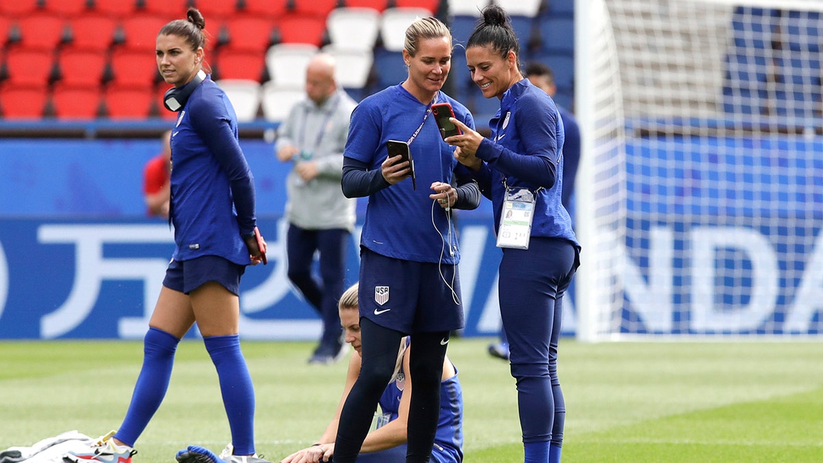 United States' Alex Morgan, left, walks past, her teammates Ashlyn Harris, center, and Ali Krieger during a visit at the Parc des Princes stadium a day before the Group F soccer match between United States and Chile. (AP Photo/Alessandra Tarantino)