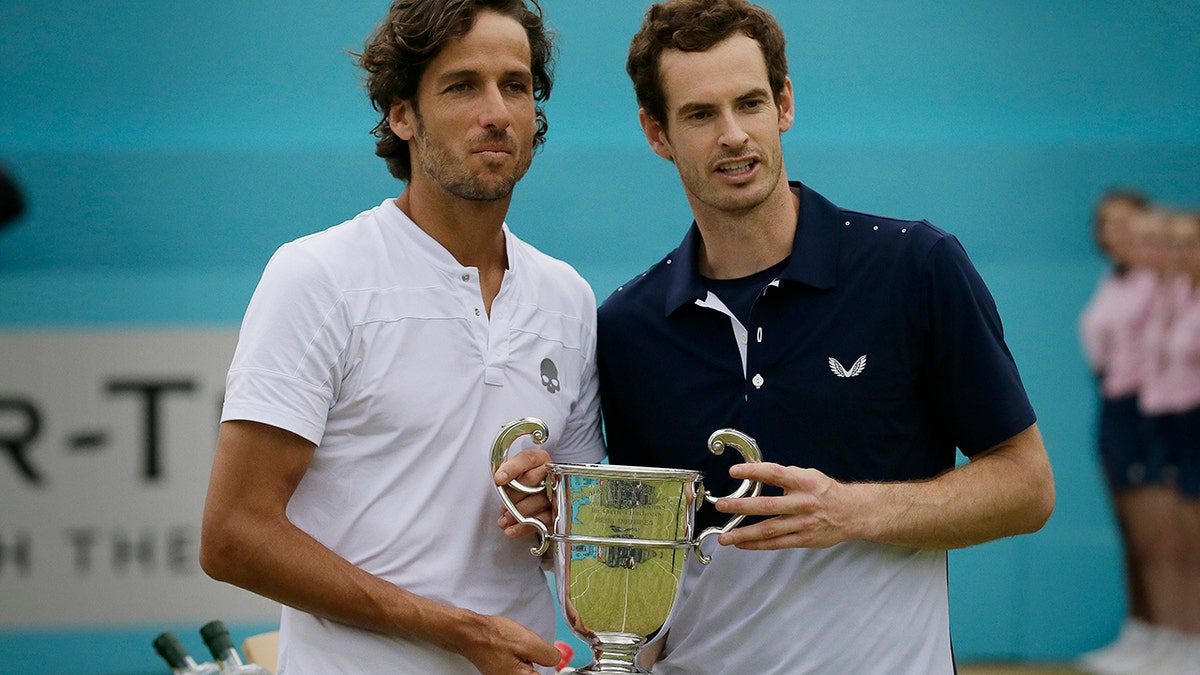Andy Murray of Britain, left, celebrates with Feliciano Lopez of Spain after winning their men's doubles final tennis match against Joe Salisbury of Britain and the Rajeev Ram of the United States at the Queens Club tennis tournament in London, Sunday June 23, 2019. (AP Photo/Tim Ireland)