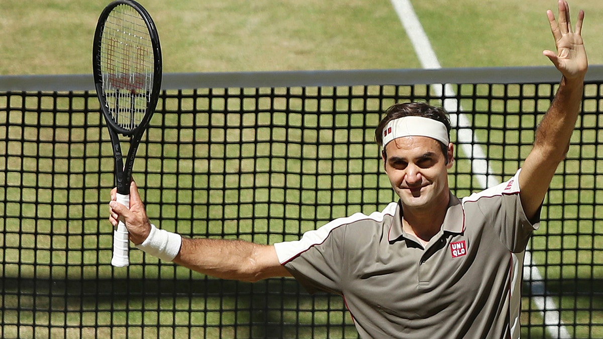 Swiss Roger Federer celebrates after winning the tennis ATP final against Belgium David Goffin in Halle, Germany, Sunday, June 23, 2019. (Friso Gentsch/dpa via AP)
