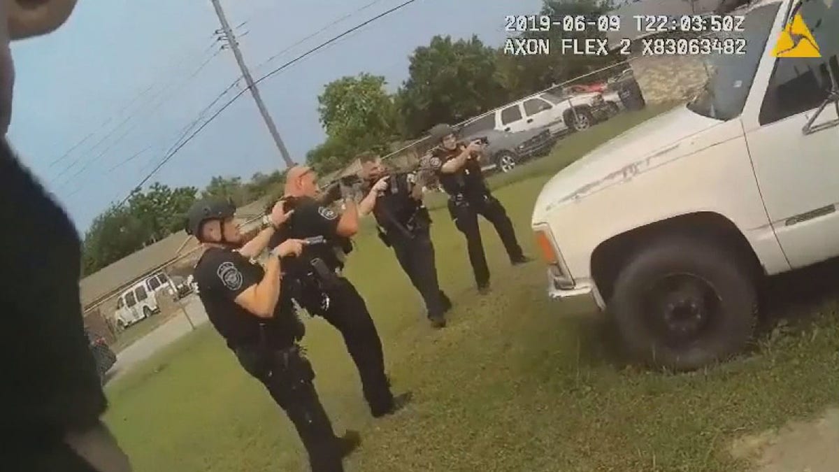 Officers can be seen forming a semi-circle around a truck where 20-year-old JaQuavion Slaton was hiding before opening fire when one officer shouted "he's reaching!"
