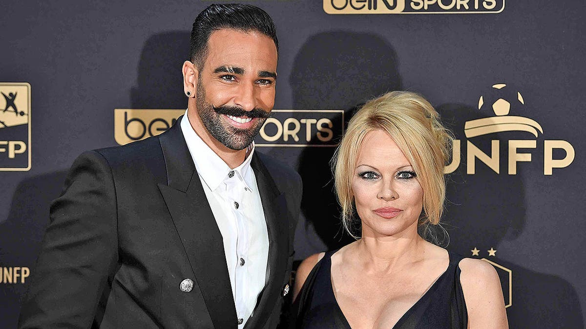 Marseille's defender Adil Rami and actress Pamela Anderson arrive to take part in a TV show on May 19, 2019 in Paris, as part of the 28th edition of the UNFP (French National Professional Football players Union) trophy ceremony. (Photo by FRANCK FIFE / AFP) (Photo credit should read FRANCK FIFE/AFP/Getty Images)