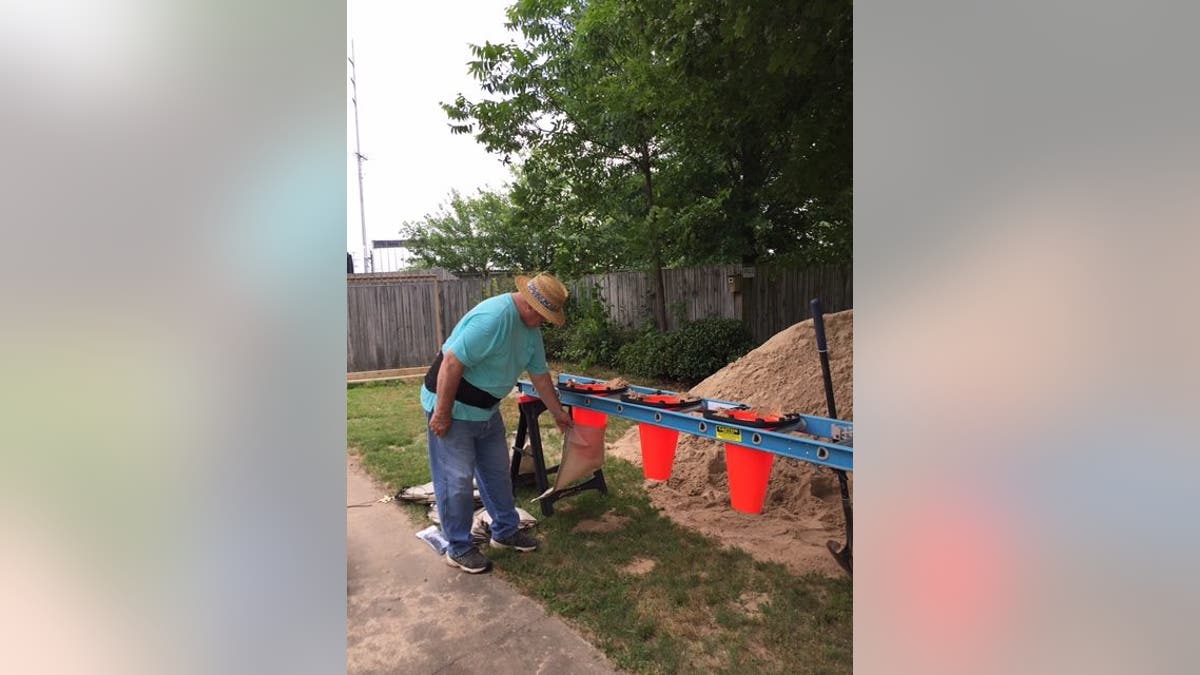 John Church filling sandbags for his Willow Beach home