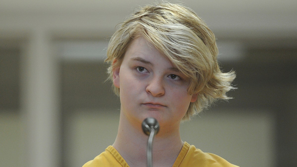 In this Sunday, June 9, 2019 photo, Denali Brehmer, 18, stands at her arraignment in the Anchorage Correctional Center in Anchorage, Alaska. (Bill Roth/Anchorage Daily News via AP)