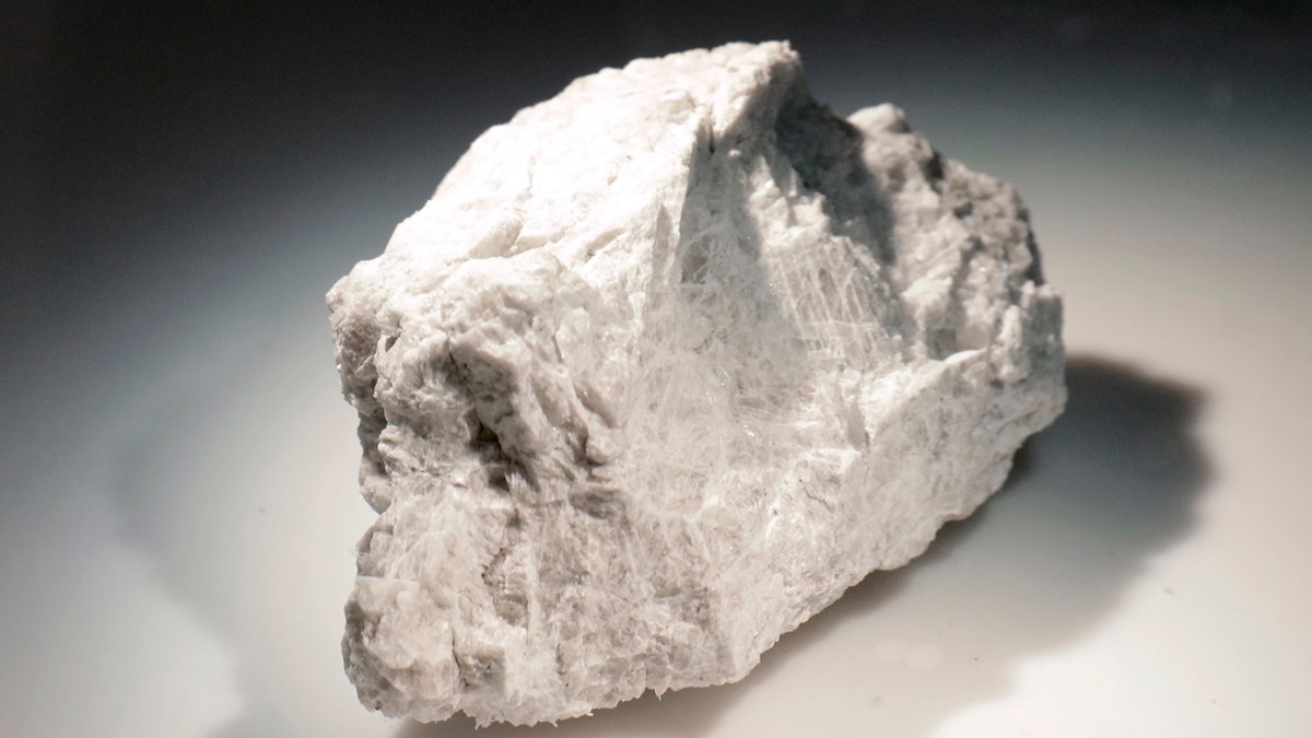 The "Genesis Rock," a 4.4 billion-year-old anorthosite sample approximately 2 inches in length, brought back by Apollo 15 and used to determine the moon was formed by a giant impact, is lit inside a pressurized nitrogen-filled examination case in the lunar lab at the NASA Johnson Space Center Monday, June 17, 2019, in Houston. (AP Photo/Michael Wyke)