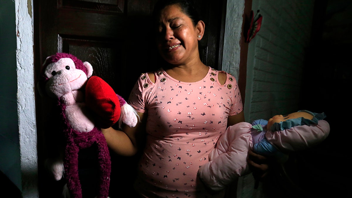 Rosa Ramirez sobs as she shows journalists toys that belonged to her nearly 2-year-old granddaughter Valeria in her home in San Martin, El Salvador, on Tuesday. (AP)