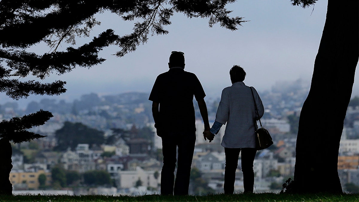 A man and woman walk under trees down a path at Alta Plaza Park in San Francisco. Data from the U.S. Census Bureau shows the median age in the U.S has increased by a year to 38.2 years from 2010 to 2018.