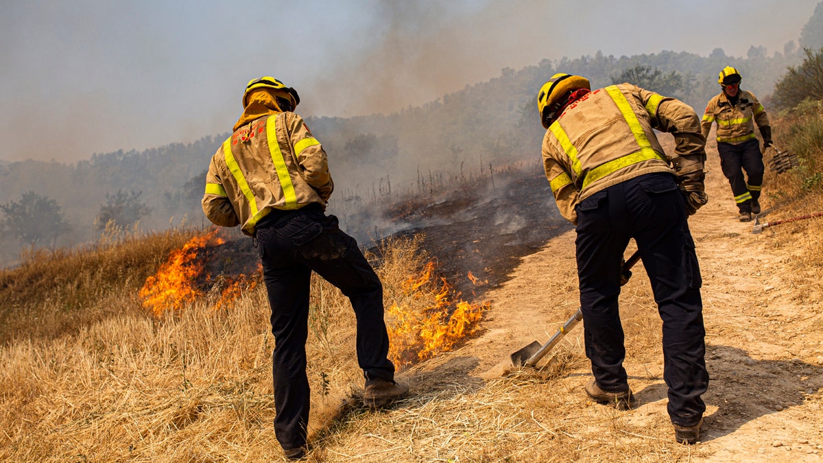 Firefighters try to extinguish a wildfire in Palma d'Ebre, near Tarragona, Spain, Thursday, June 27, 2019. Authorities suspect the cause of the outbreak was a deposit of improperly store(AP Photo/Jordi Borras)