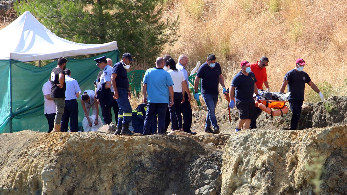 Police officials stand next to a tent where divers brought what is believed to be remains of a 6-year-old girl, near the village of Xiliatos, Cyprus, Wednesday, June 12, 2019.