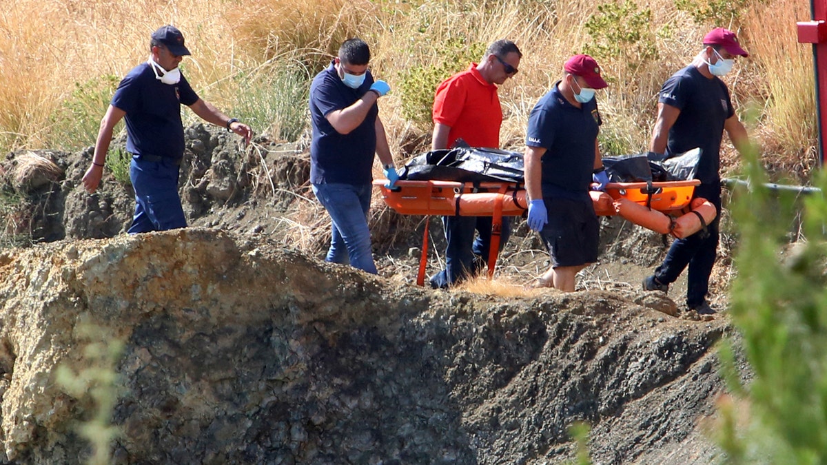 Cyprus police personnel carry a stretcher containing what is believed to be remains of a 6-year-old girl, near the village of Xiliatos, Cyprus, Wednesday, June 12, 2019.