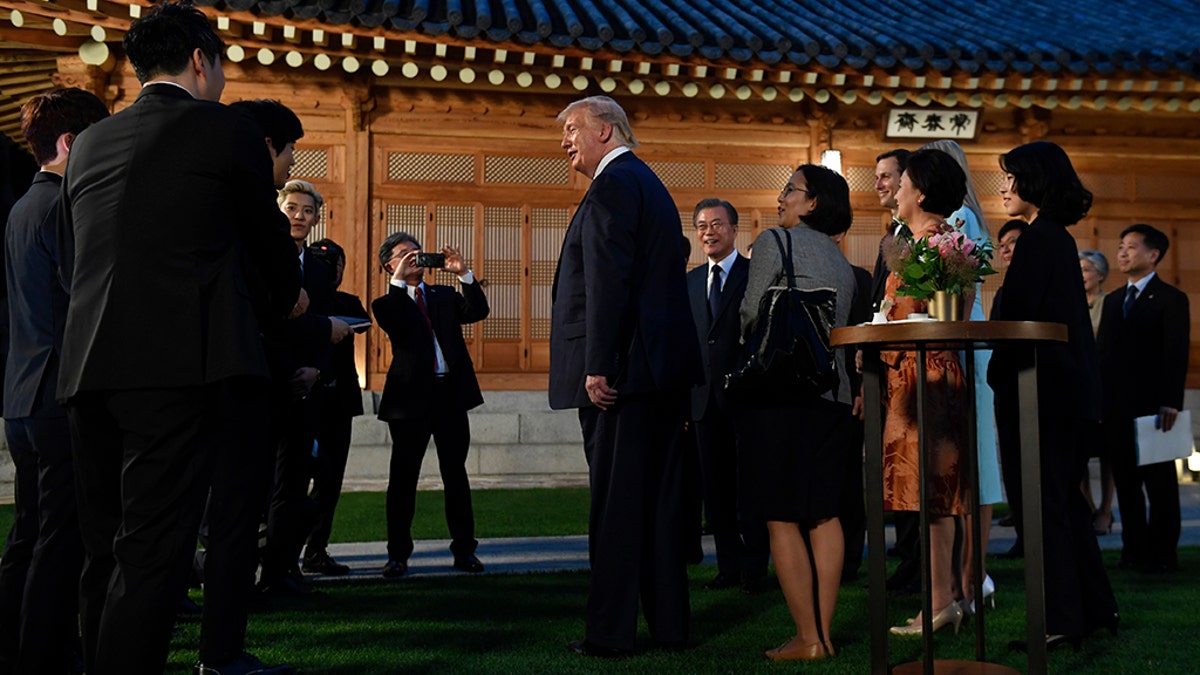 President Donald Trump, center, talks with guests including members of the band Exo during a visit with South Korean President Moon Jae-in at the tea house on the grounds of the Blue House in Seoul, South Korea, Saturday, June 29, 2019. Trump is making a quick trip to Seoul after attending the G-20 summit in Osaka, Japan.