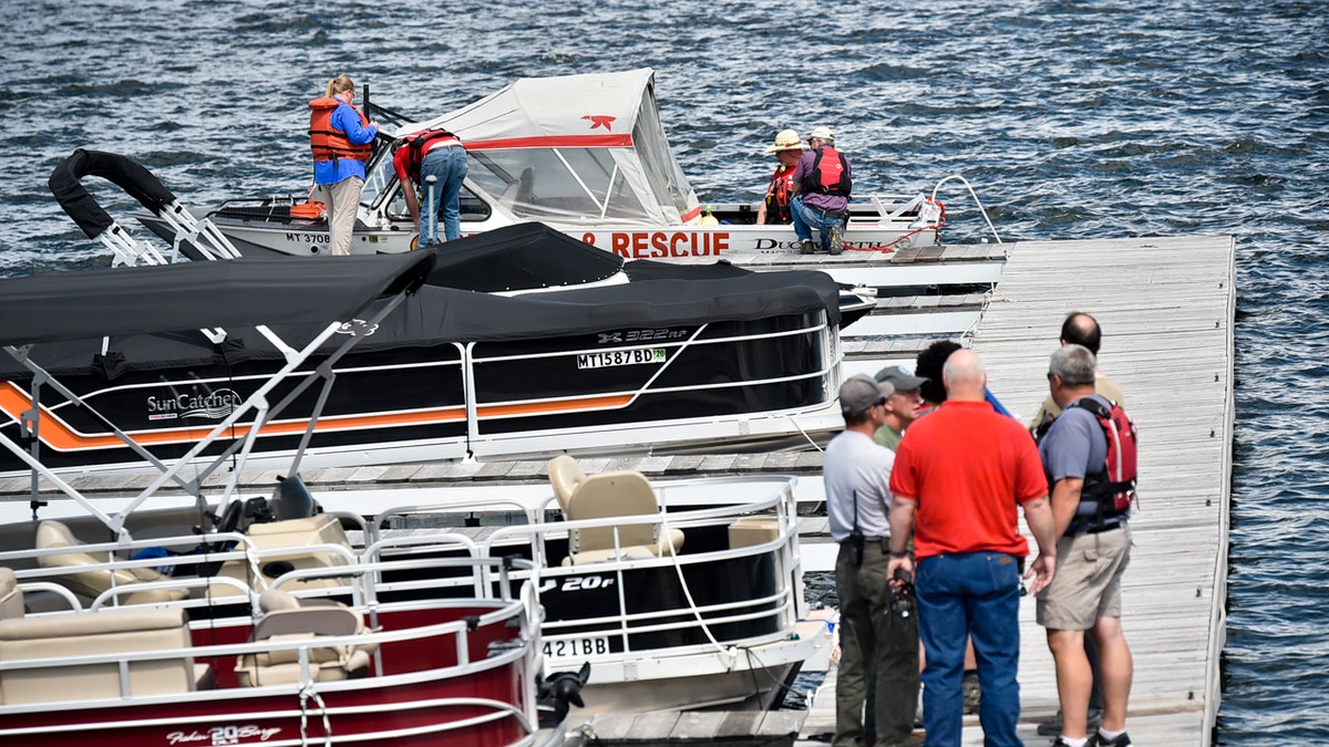 In this Monday, June 17, 2019 photo, emergency responders stage at the Yacht Basin marina east of Helena, Mont., as search and rescue teams search for a missing diver near Cemetery Island on Canyon Ferry Lake.