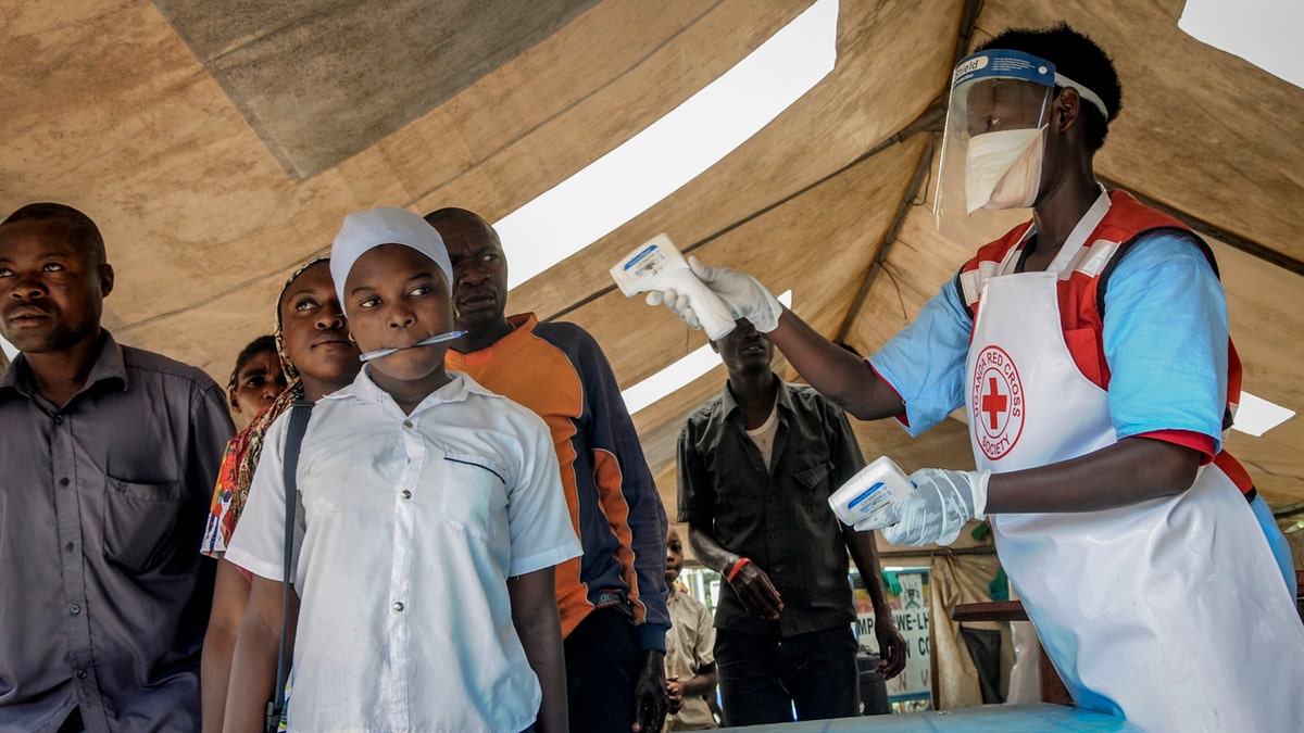 People coming from Congo have their temperature measured to screen for symptoms of Ebola, at the Mpondwe border crossing with Congo, in western Uganda Friday, June 14, 2019. (AP Photo/Ronald Kabuubi)