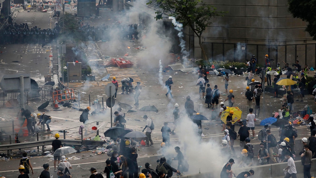 In this file photo taken Wednesday, June 12, 2019, riot police try to disperse protesters with fire tear gas outside the Legislative Council in Hong Kong.