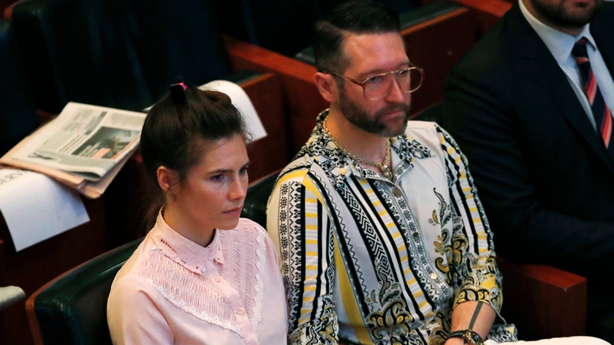 Amanda Knox holds hands with her fiancee Christopher Robinson as they attend a conference during a Criminal Justice Festival at the University of Modena, Italy, Friday, June 14, 2019. Knox, a former American exchange student who became the focus of a sensational murder case, arrived in Italy Thursday for the first time since an appeals court acquitted her in 2011 in the slaying of her British roommate. (AP Photo/Antonio Calanni)