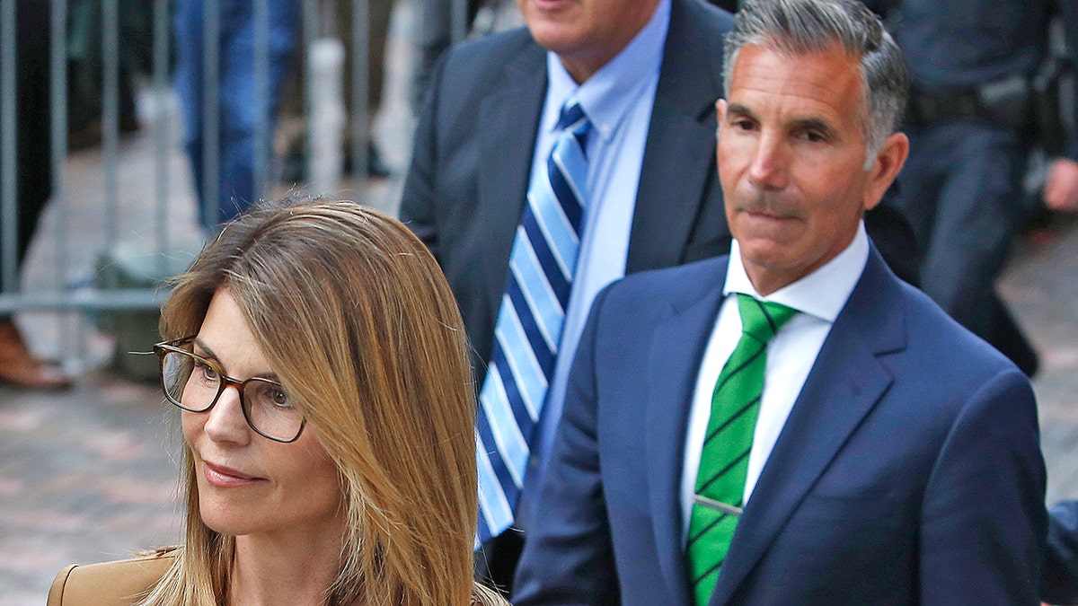 Actress Lori Loughlin, left, leaves as her husband Mossimo Giannulli, right, trails behind her outside of the John Joseph Moakley United States Courthouse in Boston on April 3, 2019. Hollywood stars Felicity Huffman and Lori Loughlin were among 13 parents scheduled to appear in federal court in Boston Wednesday for the first time since they were charged last month in a massive college admissions cheating scandal. They were among 50 people - including coaches, powerful financiers, and entrepreneurs - charged in a brazen plot in which wealthy parents allegedly schemed to bribe sports coaches at top colleges to admit their children. Many of the parents allegedly paid to have someone else take the SAT or ACT exams for their children or correct their answers, guaranteeing them high scores. (Photo by Jessica Rinaldi/The Boston Globe via Getty Images)