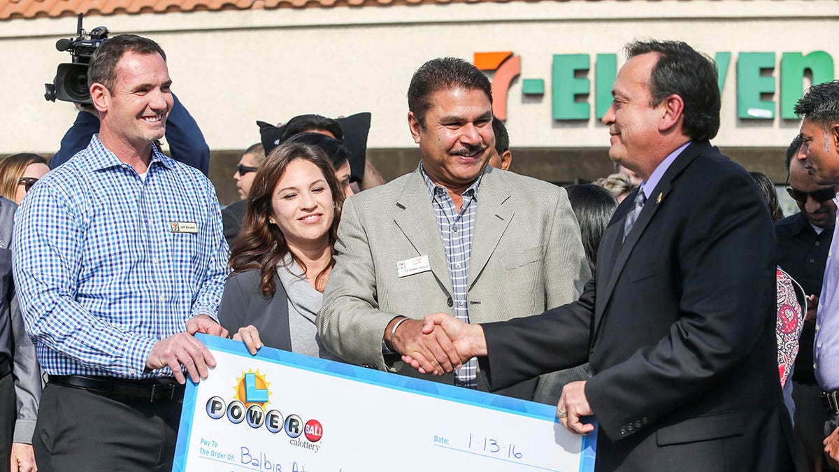 Hugo Lopez, right, resigned Friday as director of the California State Lottery. He is shown congratulating prize winners on Jan. 14, 2016, in Chino Hills, Calif. (Getty Images)