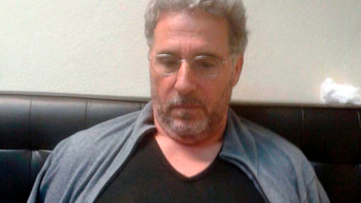 FILE - In this Sept. 3, 2017 file photo released by the Italian police, a man identified by police as longtime fugitive Rocco Morabito, looks down after being arrested at a hotel in Montevideo, Uruguay.