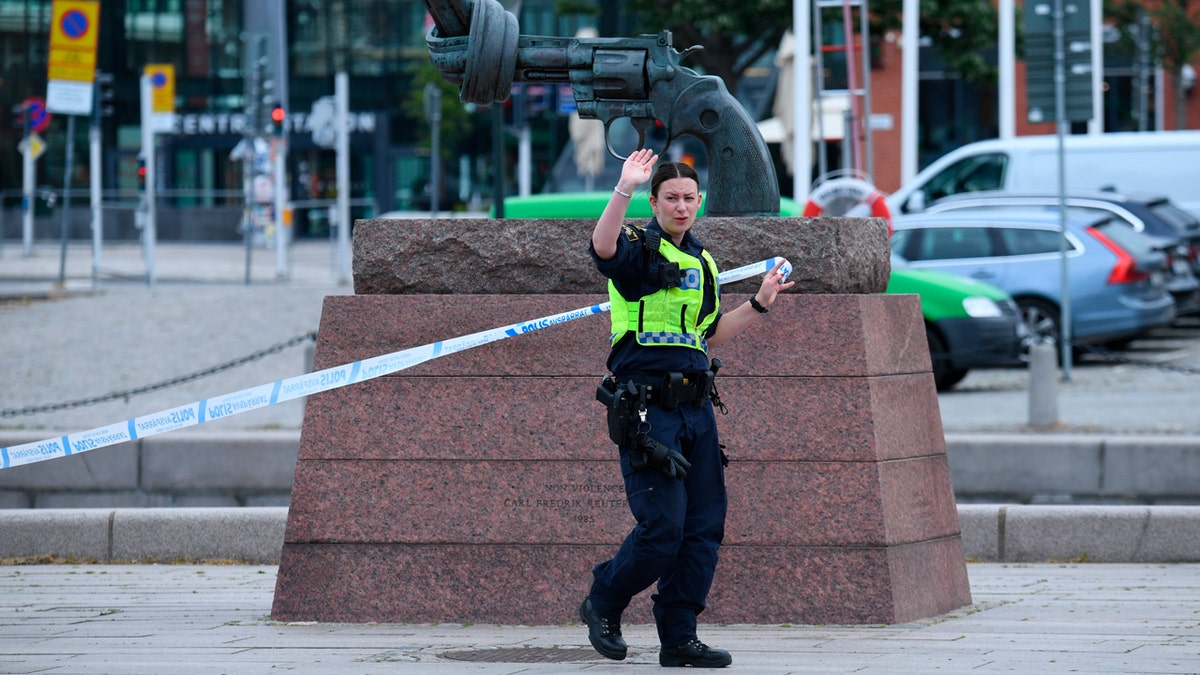 A police officer cordons off an area at the scene where police shot and wounded a man at Malmo central station, Sweden.
