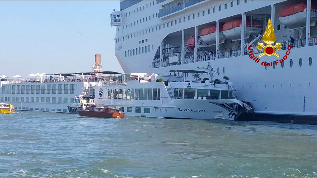 In this photo released by the Italian Firefighters, the MSC Opera cruise liner, a towering cruise ship, strikes a tourist river boat, left, Sunday, June 2, 2019, in Venice, Italy, injuring at least five people.